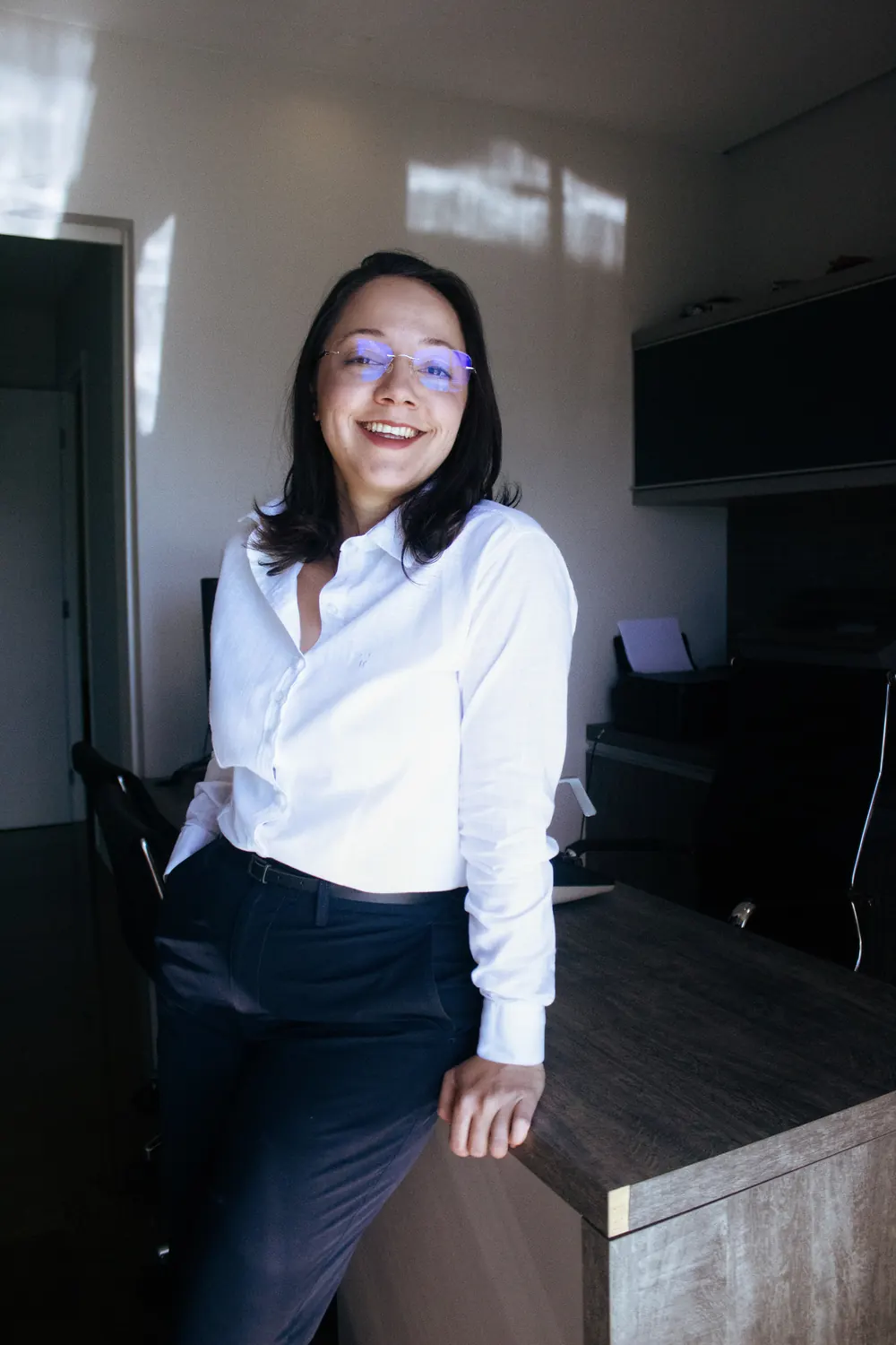 Dra. Heloise dos Santos Azevedo sorrindo em seu escritório